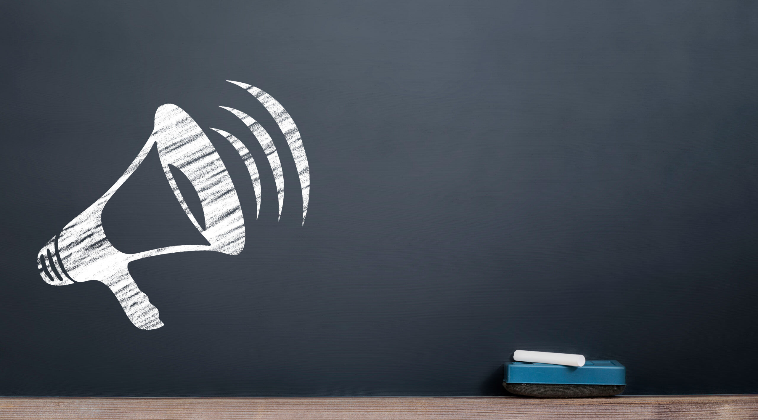 An image of a megaphone drawn on a chalk board
